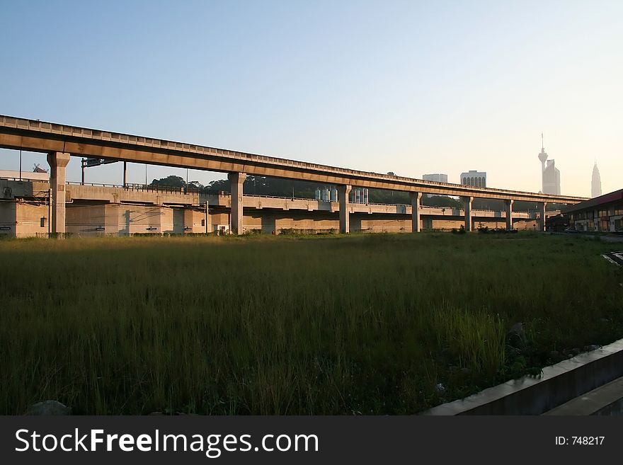 Elevated train tracks, city skyline in the early morning