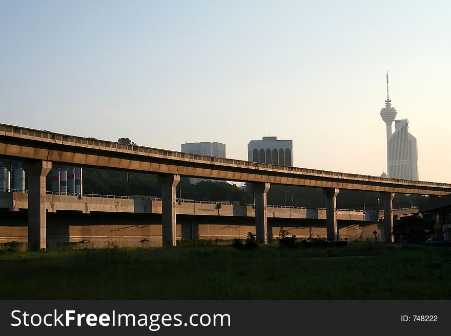 Elevated train tracks, city skyline in the early morning