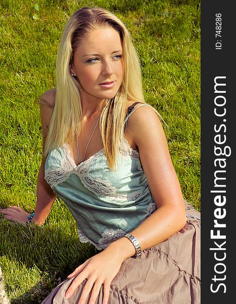 Young attractive woman sitting in the grass. Young attractive woman sitting in the grass