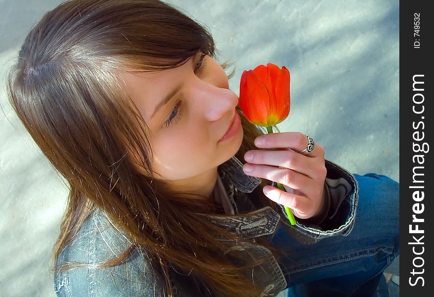 The girl with a flower on a background of asphalt. The girl with a flower on a background of asphalt