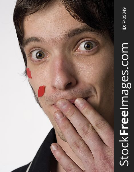 Portrait of a young man on a white background with novelty kisses on his face