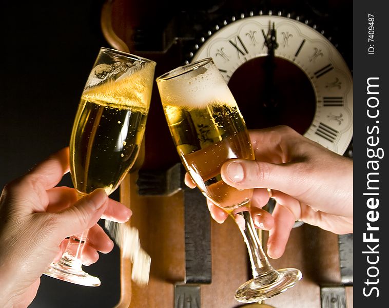 Champagne toast at midnight with clock in the background