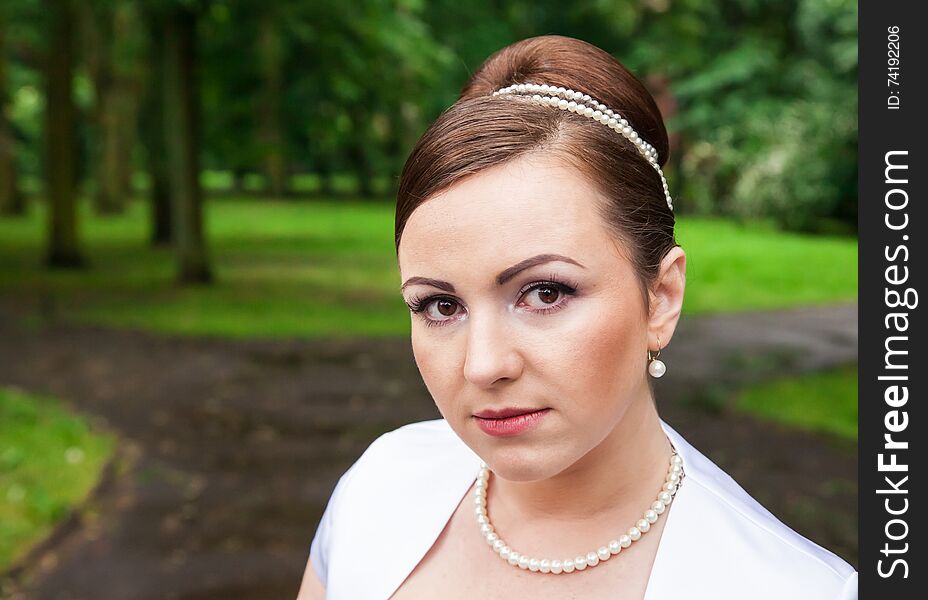 Portrait of a bride in a city park on summer day