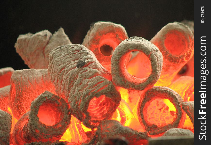 A closeup shot of burning hot cylinder shaped charcoal. A closeup shot of burning hot cylinder shaped charcoal