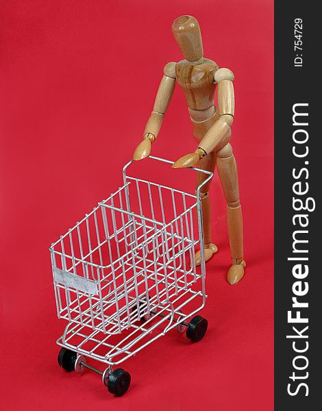 Wood model pushing a shopping cart. Wood model pushing a shopping cart