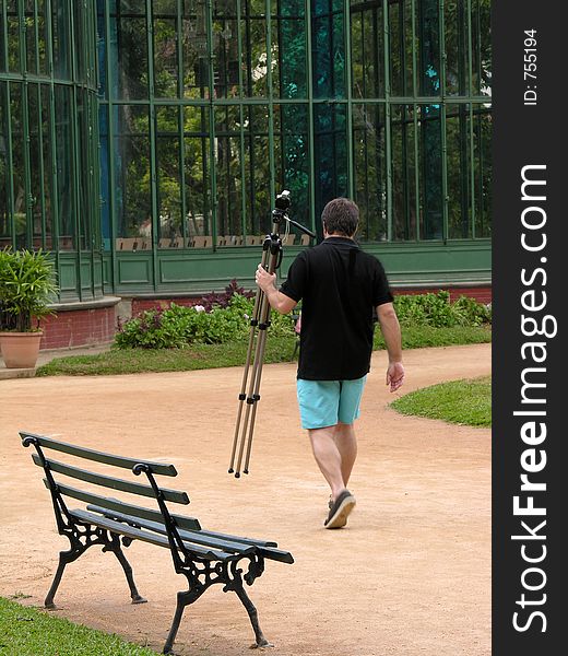 Walking photographer holding a tripod. Walking photographer holding a tripod