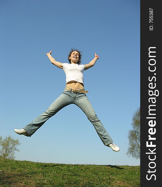 Jump girl on meadow. blue sky