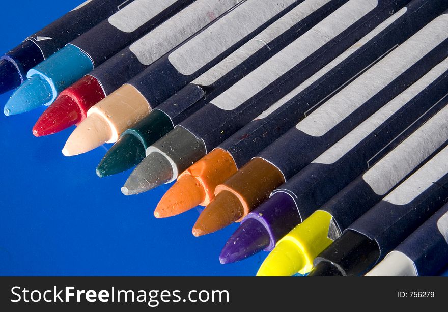 Several colored crayons on a blue background. Several colored crayons on a blue background
