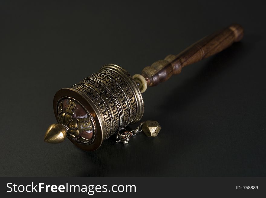 Tibetian manual prayer wheel on dark background. Tibetian manual prayer wheel on dark background