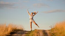 Happy Beautiful Young Girl Dancing In A Field Royalty Free Stock Photography