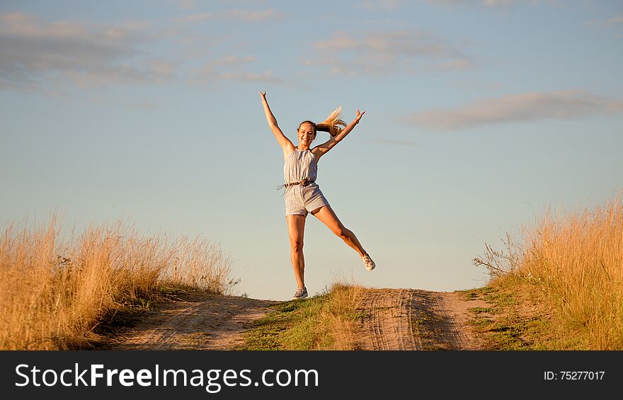 Happy Beautiful Young Girl Dancing In A Field