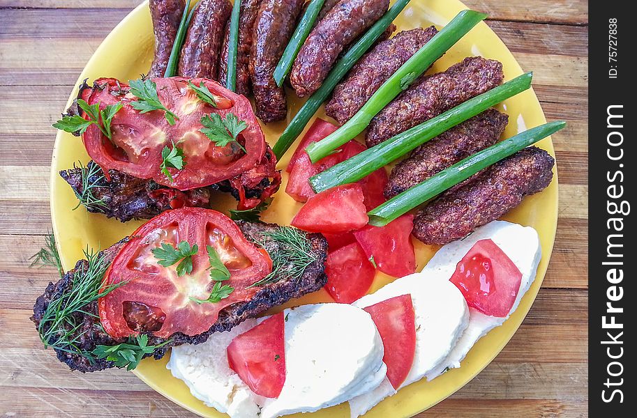 Picture with traditional romanian food with grilled sausages and barbeque ,sheep,mititei and tomatoes. Picture with traditional romanian food with grilled sausages and barbeque ,sheep,mititei and tomatoes