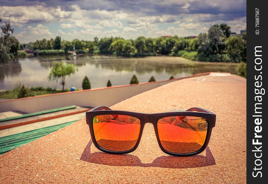 Picture with summer fashion orange polarized eyewhear and beautiful blue clouds after storm. Picture with summer fashion orange polarized eyewhear and beautiful blue clouds after storm