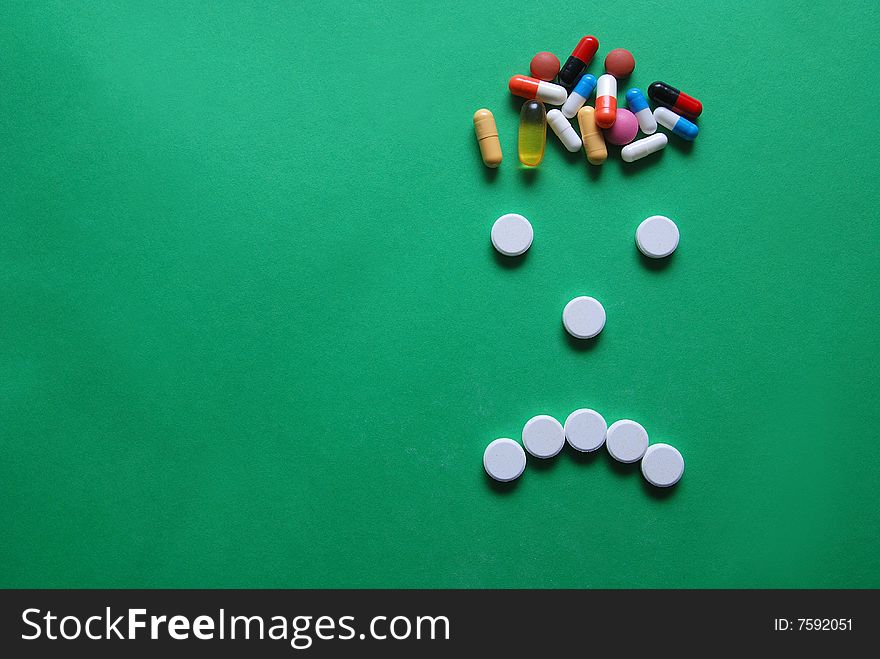Headache caricature with pills on green background
