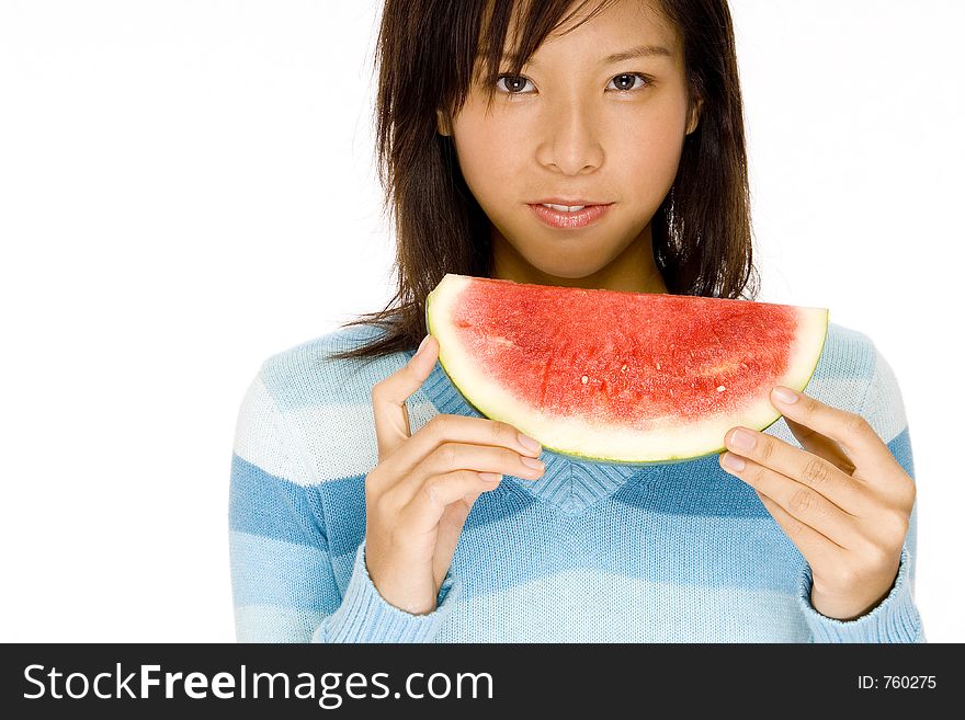 A serious looking girl holding slice of melon. A serious looking girl holding slice of melon