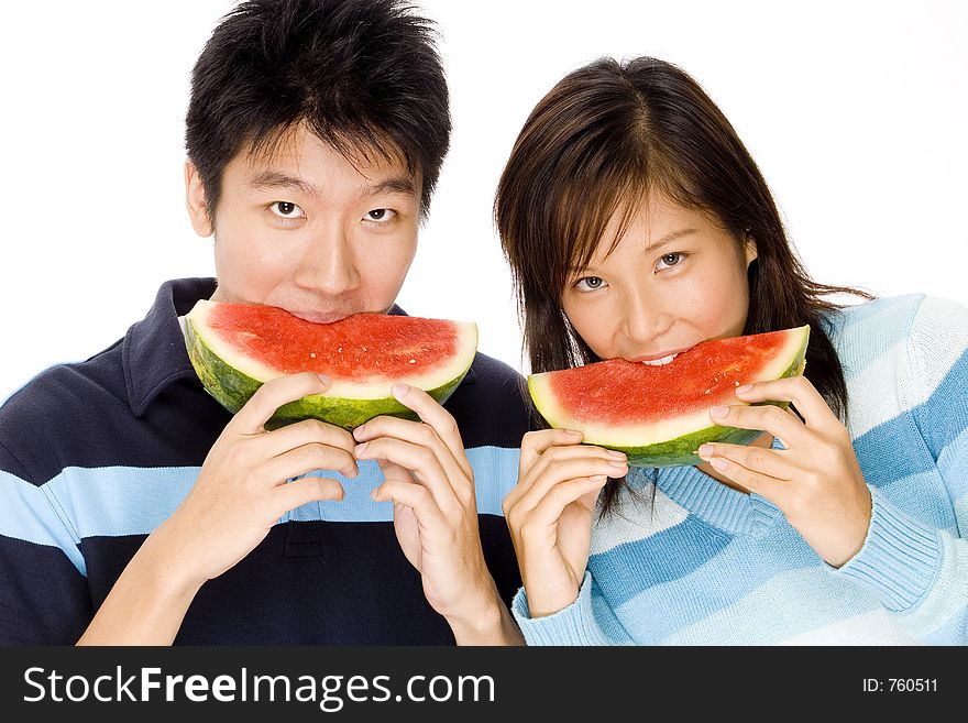 A young asian couple enjoy tropical watermelon. A young asian couple enjoy tropical watermelon