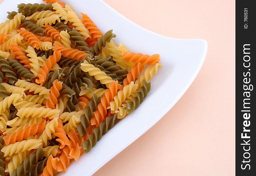 Three colors of pasta on a white plate