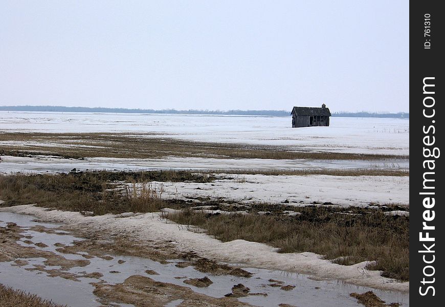 This image depicts a field in the winter with an old, abandoned shack in it. This image depicts a field in the winter with an old, abandoned shack in it.