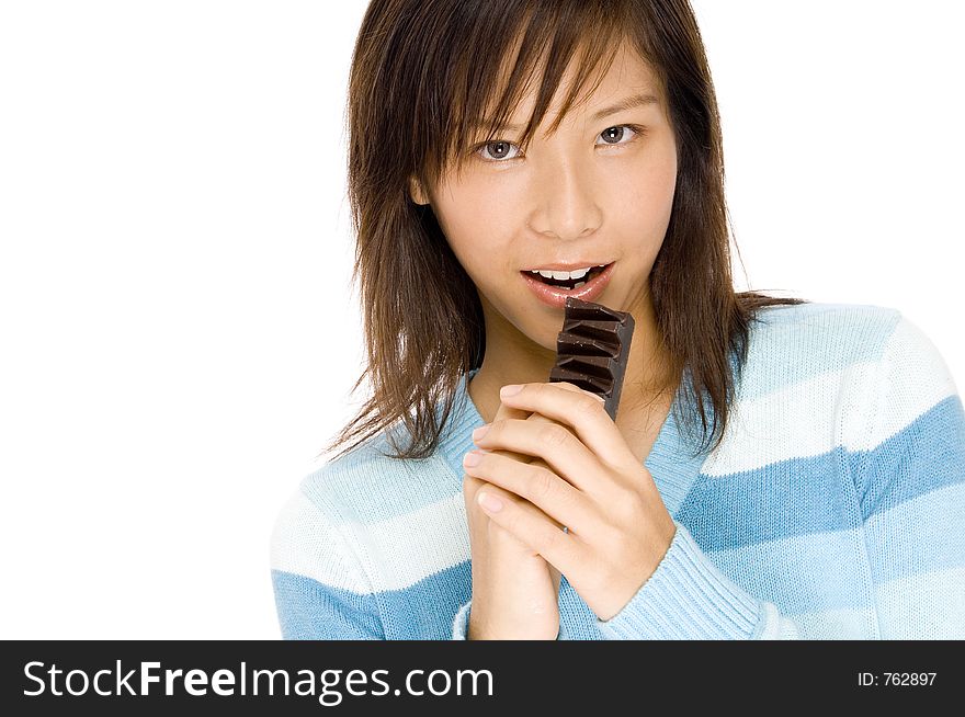 A pretty asian woman gripping a bar of chocolate. A pretty asian woman gripping a bar of chocolate