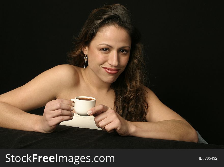 Beautiful brunette Brazilian woman holds a cup of hot chocolate or coffee. Beautiful brunette Brazilian woman holds a cup of hot chocolate or coffee