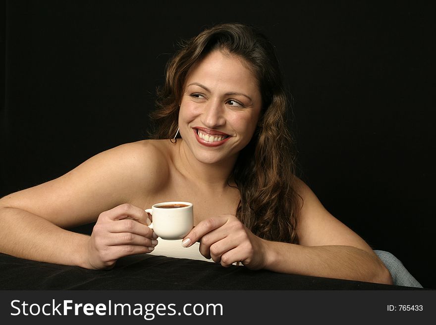 Beautiful brunette Brazilian woman smiling holds a cup of hot chocolate or coffee. Beautiful brunette Brazilian woman smiling holds a cup of hot chocolate or coffee