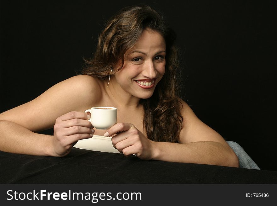 Beautiful brunette Brazilian woman smiling holds a cup of hot chocolate or coffee. Beautiful brunette Brazilian woman smiling holds a cup of hot chocolate or coffee