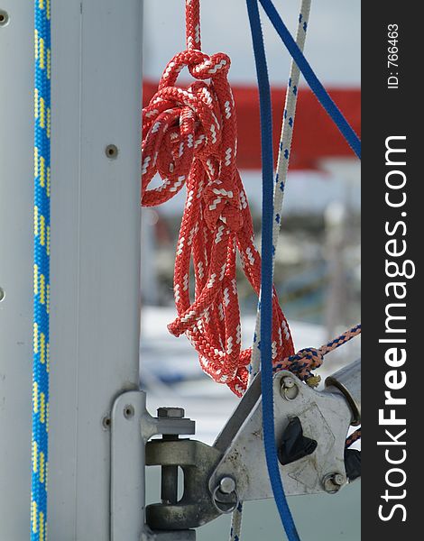 Red halyard hanging from the aluminum mast of a racing yacht. Red halyard hanging from the aluminum mast of a racing yacht