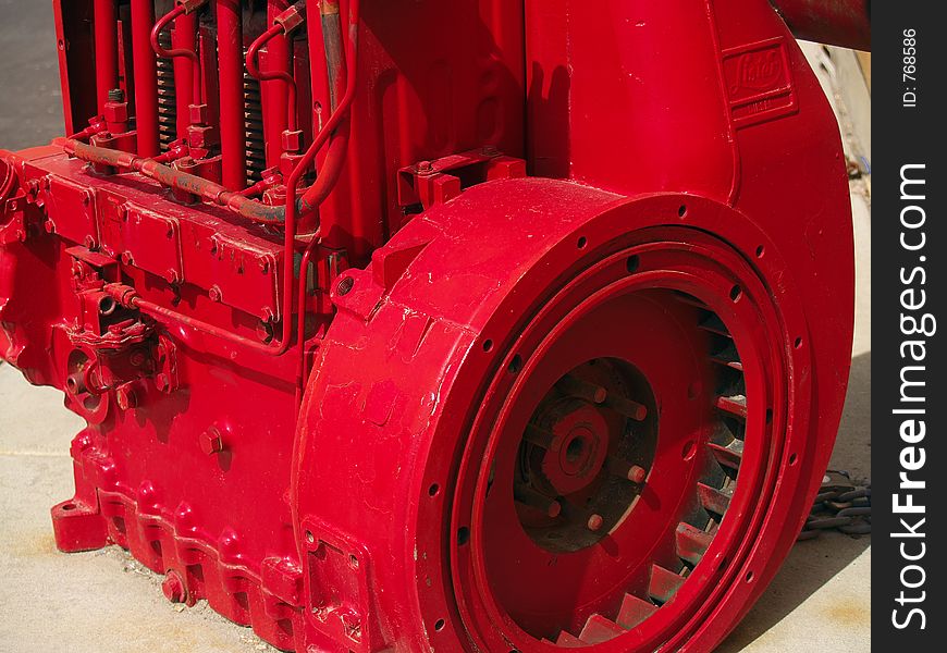 Bright red painted industrial engine with flywheel and valve springs showing. Bright red painted industrial engine with flywheel and valve springs showing.