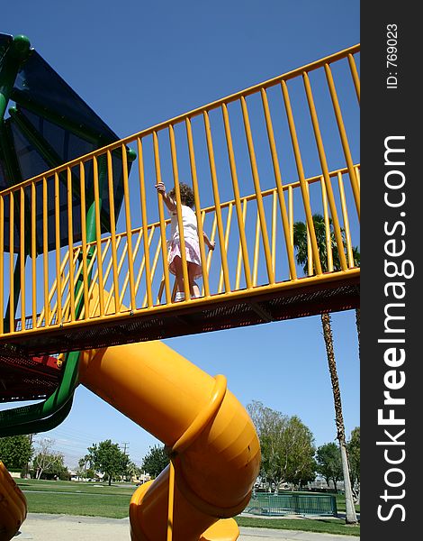 Little girl running through playground bridge. Little girl running through playground bridge