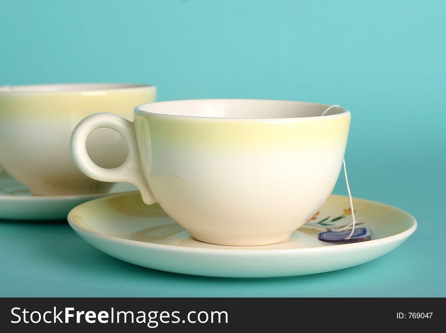 Two vintage yellow teacups with teabag; fresh color scheme. Two vintage yellow teacups with teabag; fresh color scheme