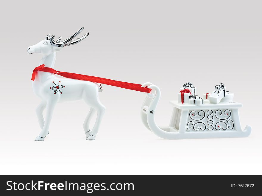 Figurine of reindeer pulling Santa's sleigh full of presents, against white background. Figurine of reindeer pulling Santa's sleigh full of presents, against white background