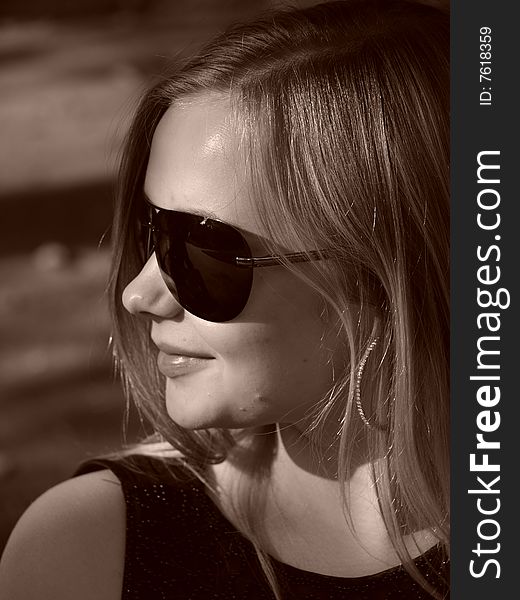 Young smiling woman with big sun glasses in sepia. Young smiling woman with big sun glasses in sepia