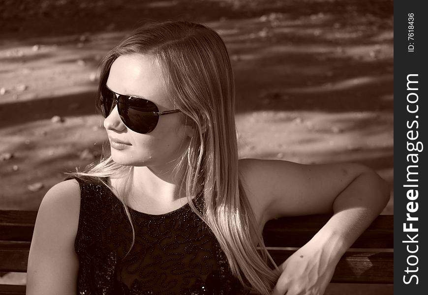 Young woman with big sun glasses in sepia