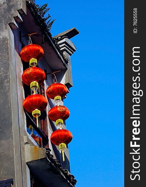 Some red lantern hang out  on the house. Some red lantern hang out  on the house