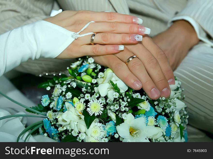 Beautiful wedding bouquet and hands of happy newlyweds