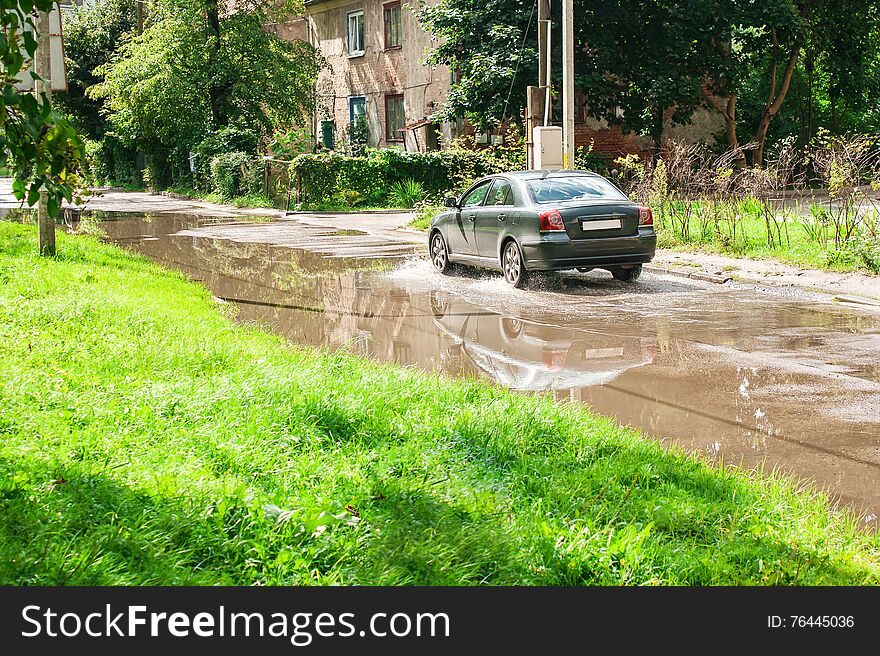 Car Riding On Big Puddle On The Road