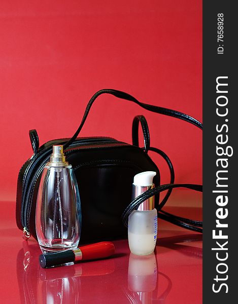 Cosmetics and perfume in a black purse