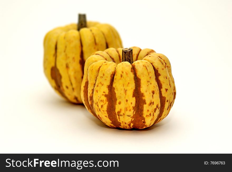 Colocynth alias Bitter-apple. In french Coloquinte. Sort of pumpkin, isolated on a white background. The other one is blurry. Colocynth alias Bitter-apple. In french Coloquinte. Sort of pumpkin, isolated on a white background. The other one is blurry.