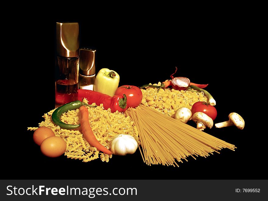 Varieties of pasta, olive oil, tomatoes and garlic, onion, eggs, mushrooms and chili isolated on black. Varieties of pasta, olive oil, tomatoes and garlic, onion, eggs, mushrooms and chili isolated on black