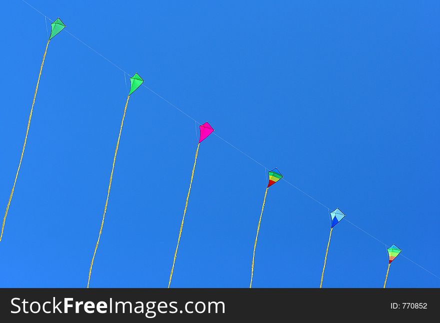 A series of kites on a blue sky background