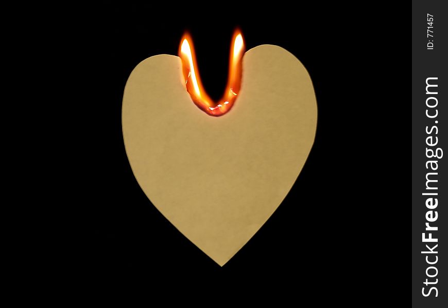 High-resolution digital photo of handcrafted grunge paper heart on fire with U-shaped flame means Love You (suspending in the air with black background)