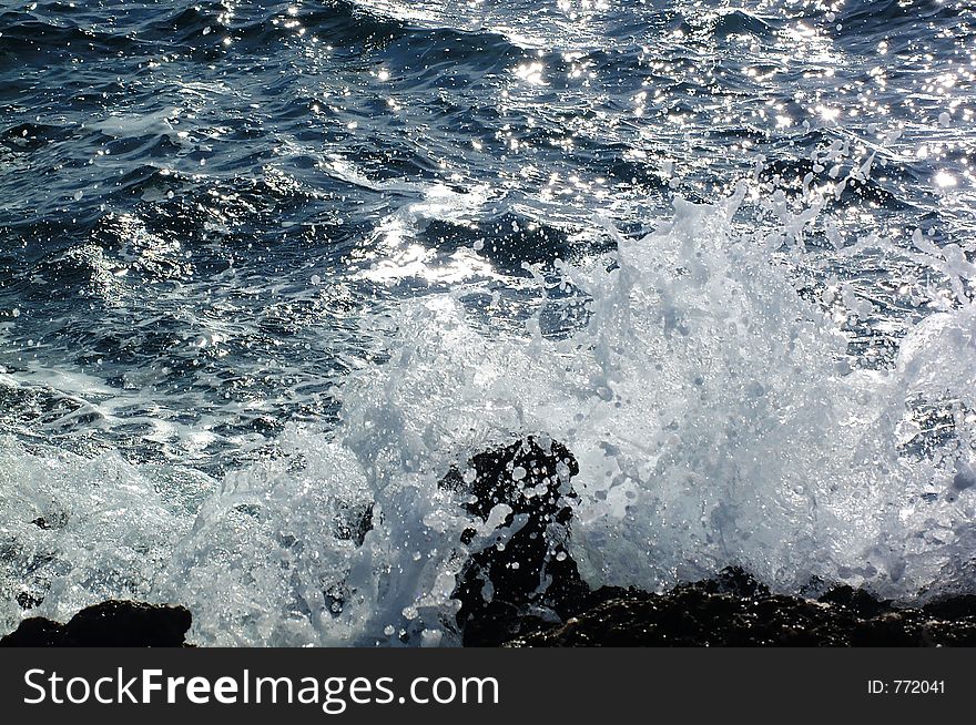 Wave breaking on rocks. Wave breaking on rocks