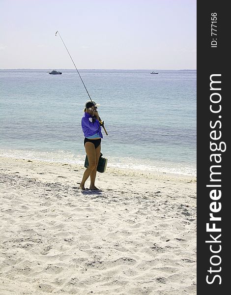 Girl going fishing while talking on her cell phone