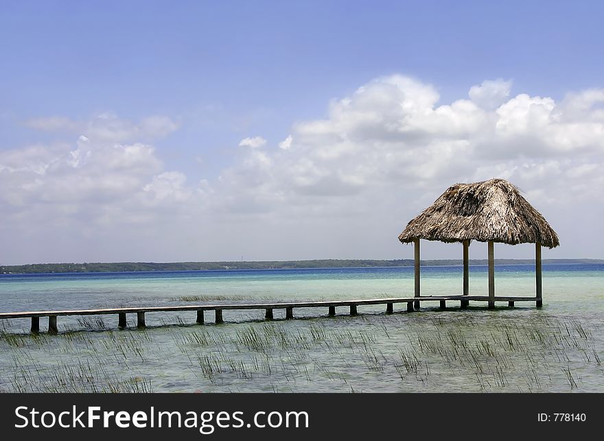 A palapa hut on the turquoise waters of Lake Bacalar, Quintana Roo, Mexico. A palapa hut on the turquoise waters of Lake Bacalar, Quintana Roo, Mexico
