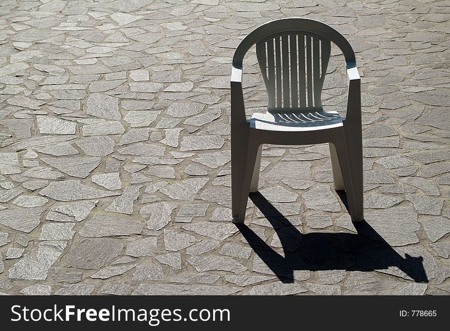 Single chair on stone pavement