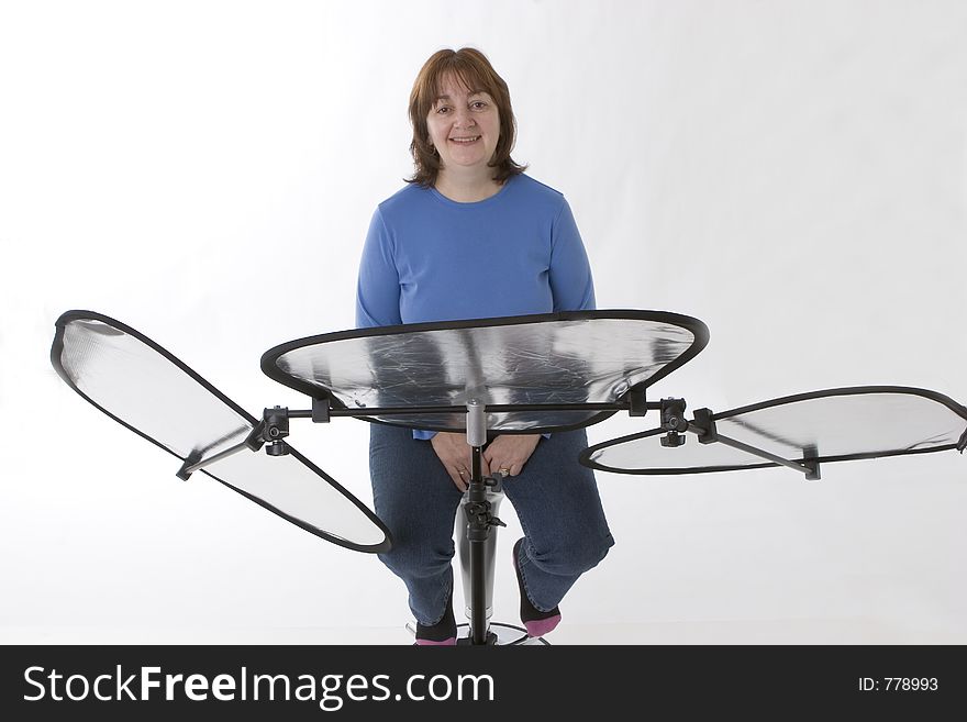 Model in front of reflectors in studio set up against white backdrop. Model in front of reflectors in studio set up against white backdrop