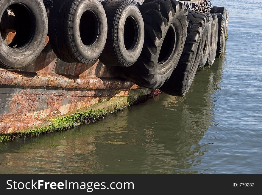 Old tires serve as bumpers for a tug boat. Old tires serve as bumpers for a tug boat.