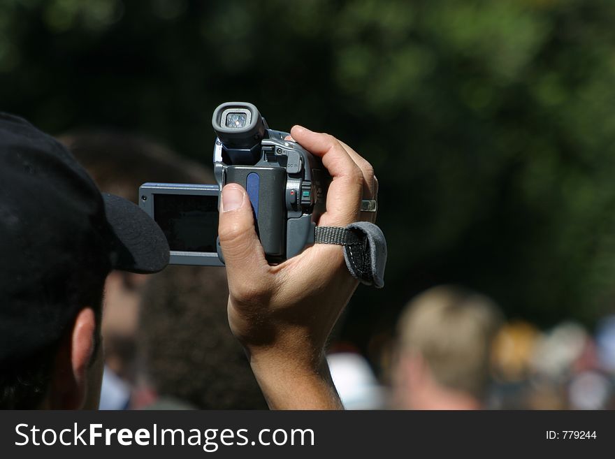 A man videotapes an event. A man videotapes an event.