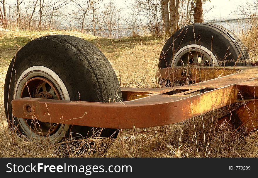 Old machinery part with two wheels abandoned in a park, in rural