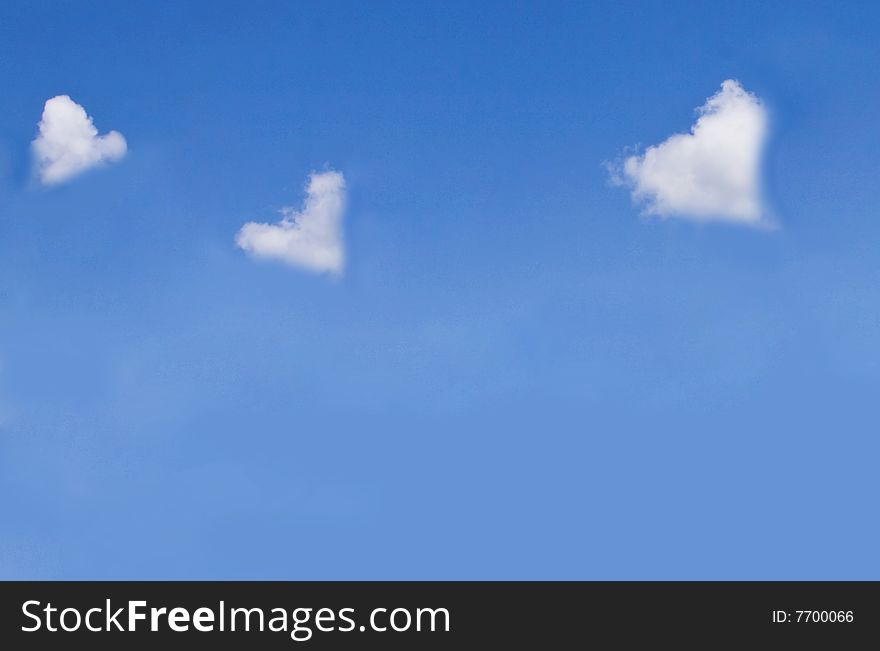 Fluffy heart shaped clouds on blue sky